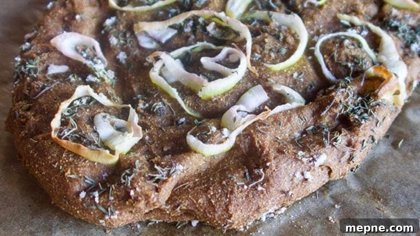 13 Low-Carb Holiday Appetizers to Impress Guests 12 Close-up of a homemade focaccia bread with onions and herbs on a textured surface.