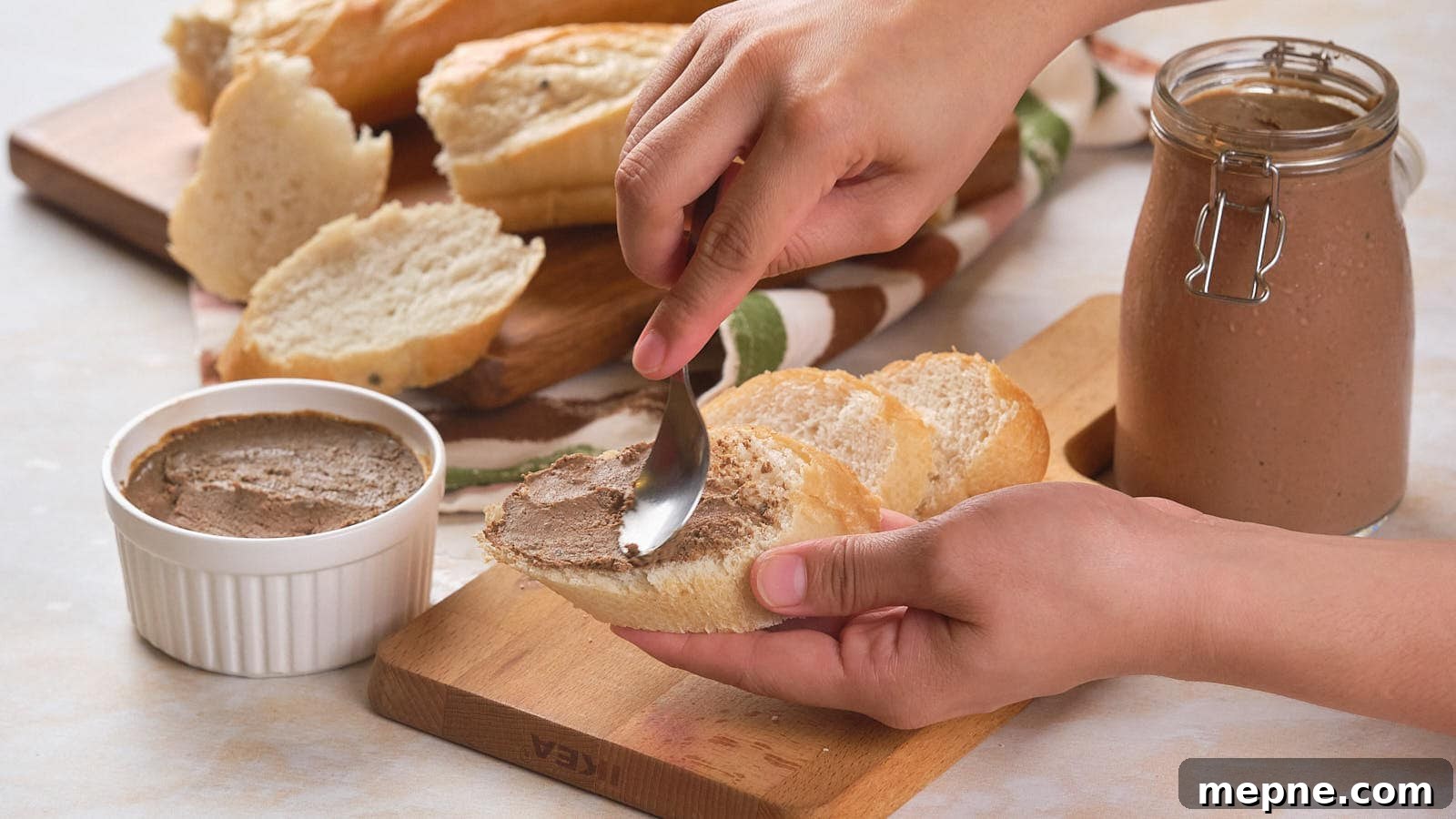 13 Low-Carb Holiday Appetizers to Impress Guests 13 A person spreads beef pâté on a piece of bread. Several slices of bread and a jar of pâté are on the table.