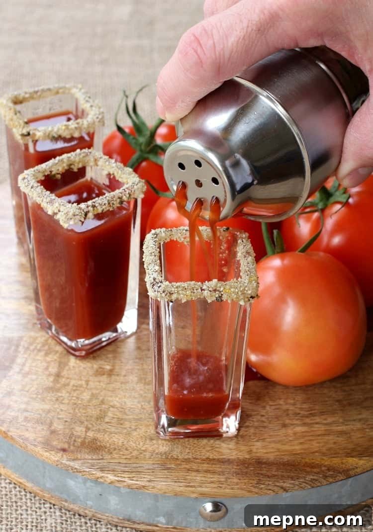 cocktail being strained into a shot glass