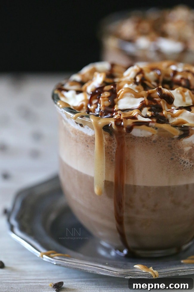 Serve with chocolate sauce and a peanut butter drizzle for a decadent finish. Peanut Butter Hot Chocolate topped with chocolate sauce and peanut butter.