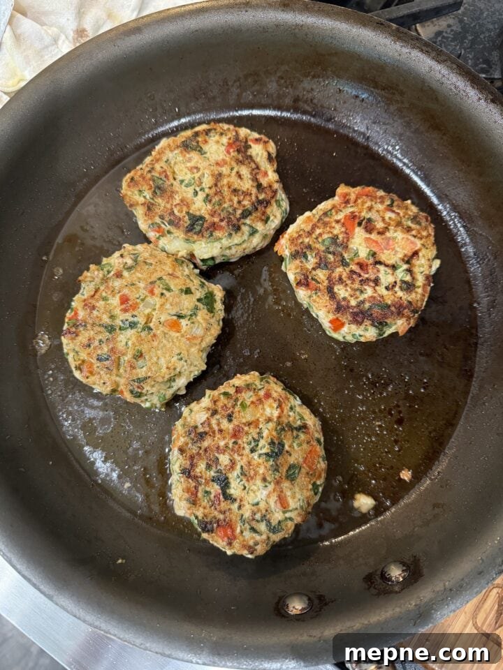 Smoky Chicken Patty Bowl: Weeknight Chicken Burger Recipe 12 four chicken patties cooking in a nonstick pan