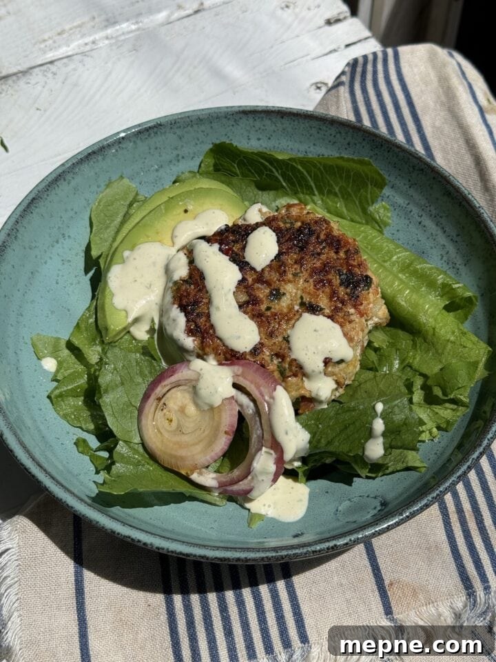 Smoky Chicken Patty Bowl: Weeknight Chicken Burger Recipe 3 chicken patty over romain with red onions and white dressing in a a blue bowl