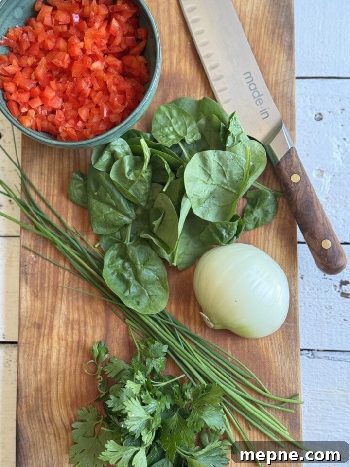 Smoky Chicken Patty Bowl: Weeknight Chicken Burger Recipe 5 bowl of diced red pepper next to knife spinach half white onion chives and parsley on a wood board
