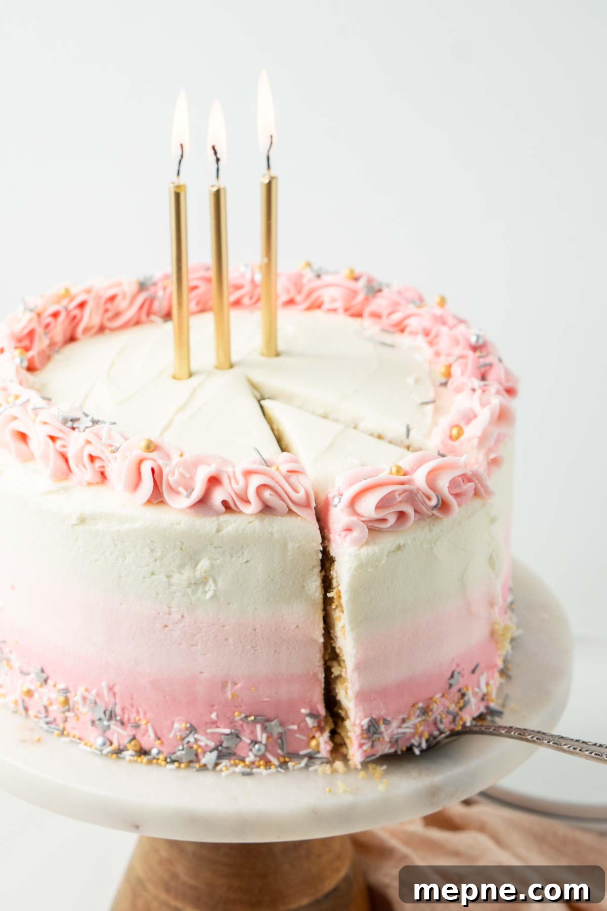 Vegan Vanilla Cake with Fluffy Frosting 3 Vegan birthday cake with gold candles and a slice cut ready to serve.