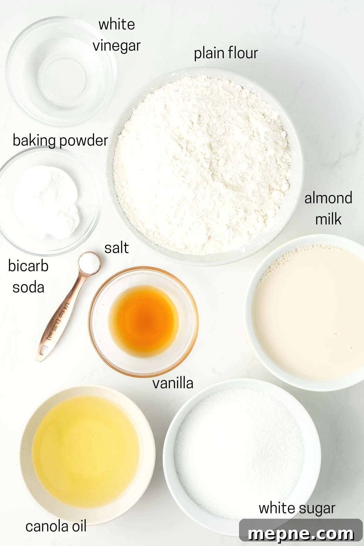 Vegan Vanilla Cake with Fluffy Frosting 4 All ingredients needed to make the cake laid out in small bowls.