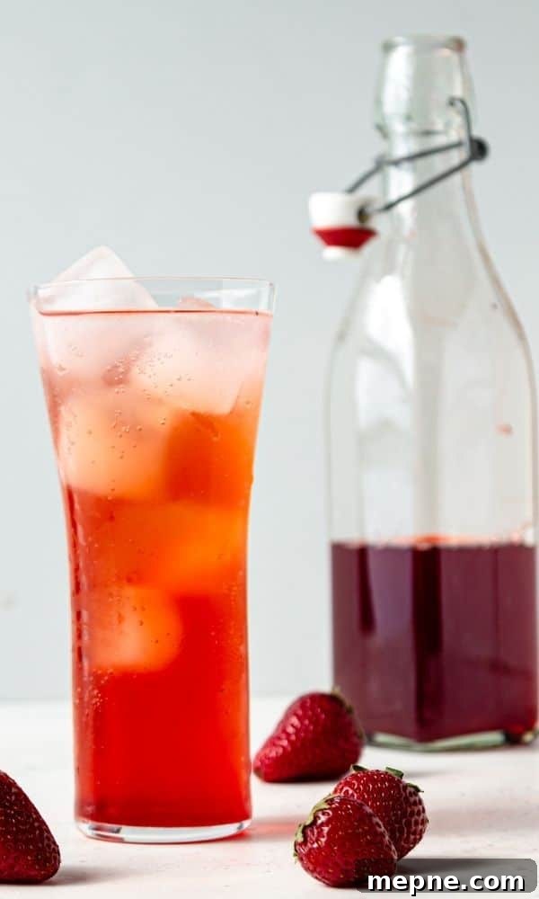 Homemade Strawberry Syrup for Cocktails and Mocktails 7 flavored syrup in jar and drink with berries around it on table