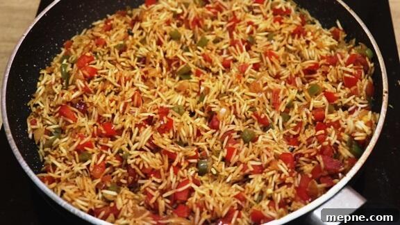 Cajun Chicken and Rice Skillet 7 sateting rice with vegetables in the pan.