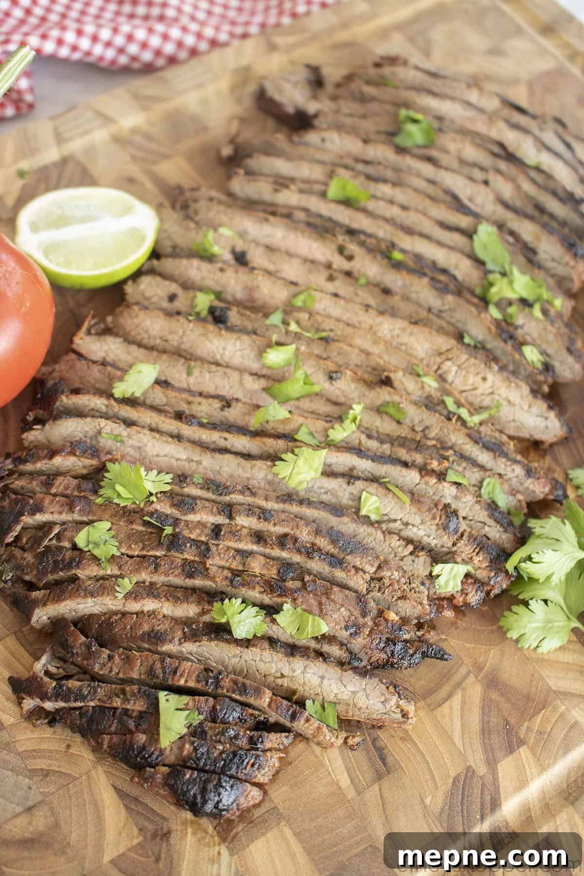 Grilled Carne Asada with Citrus Marinade 3 Sliced flank steak for tacos on a cutting board.