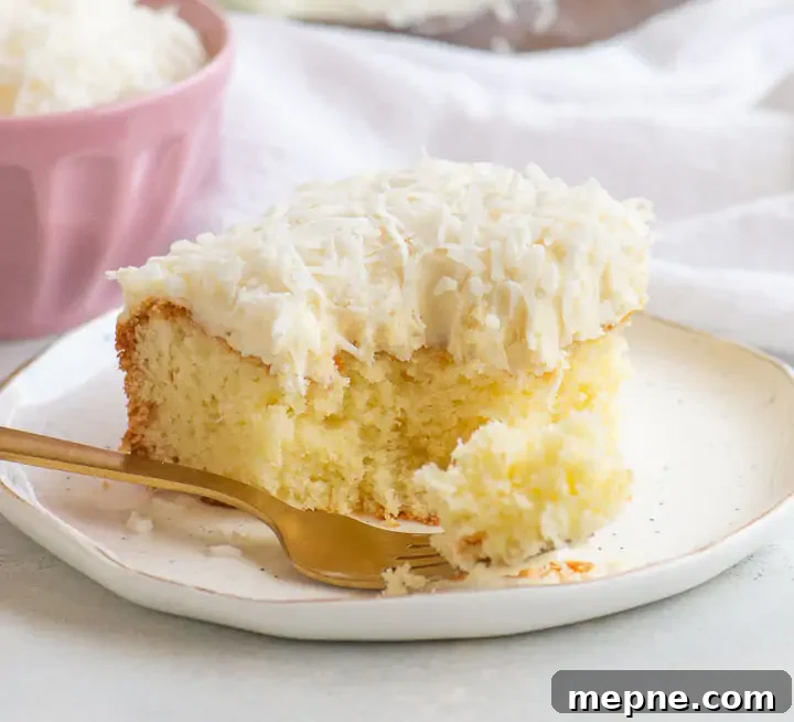Moist Coconut Sour Cream Cake Recipe with Toasted Coconut 5 slice of cake on a plate with a pink dish of coconut behind it