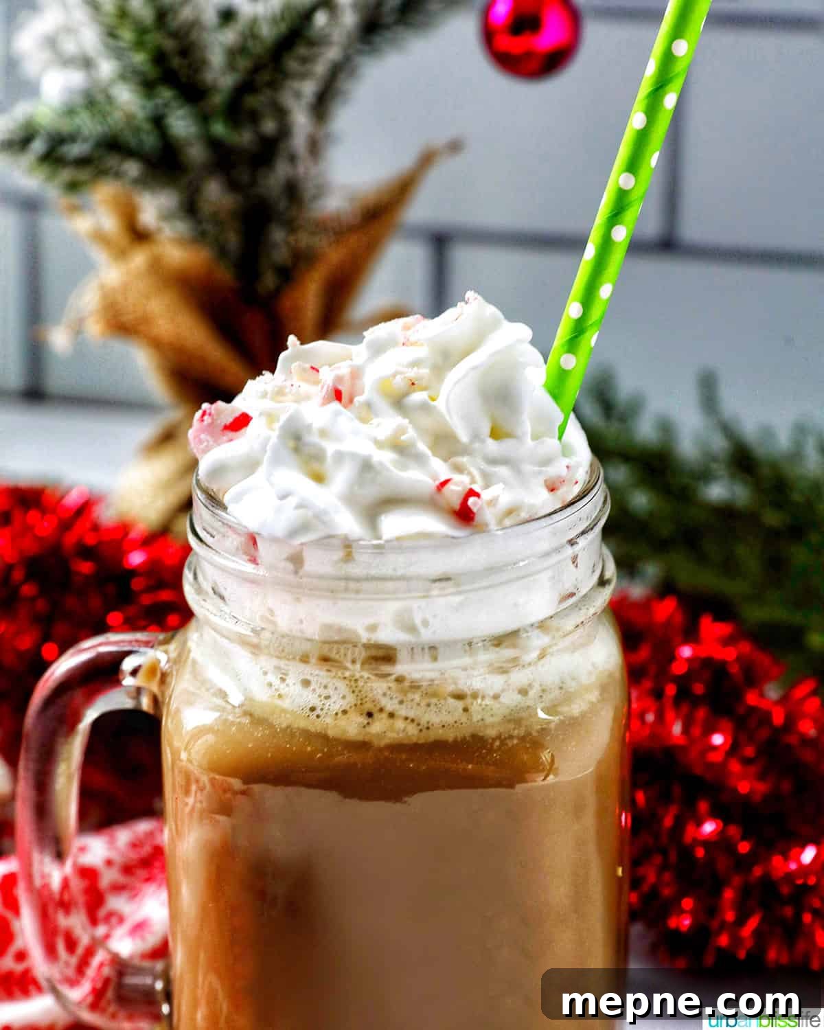 White Chocolate Peppermint Mocha Recipe 13 glass mug of white chocolate peppermint mocha with whipped cream and a green straw.