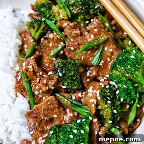 slow cooker beef and broccoli with white rice in a bowl.