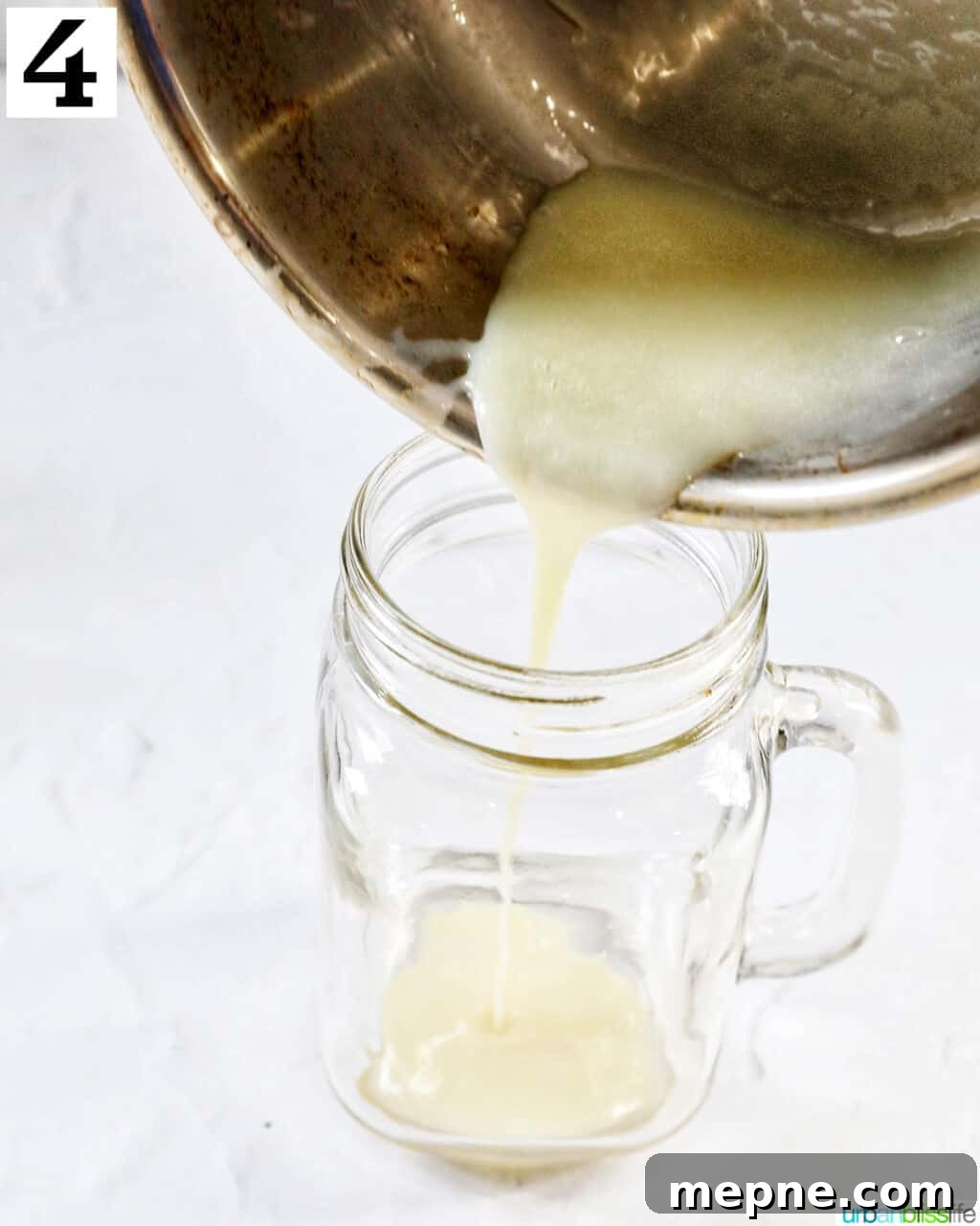 White Chocolate Peppermint Mocha Recipe 9 Pouring melted white chocolate into a clear glass mug.