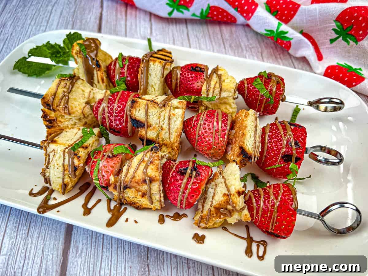 33 BBQ Recipes That Turn Budget Cuts Into Gourmet Meals 11 Three pieces of Grilled Strawberry Shortcake Skewers on a white plate.