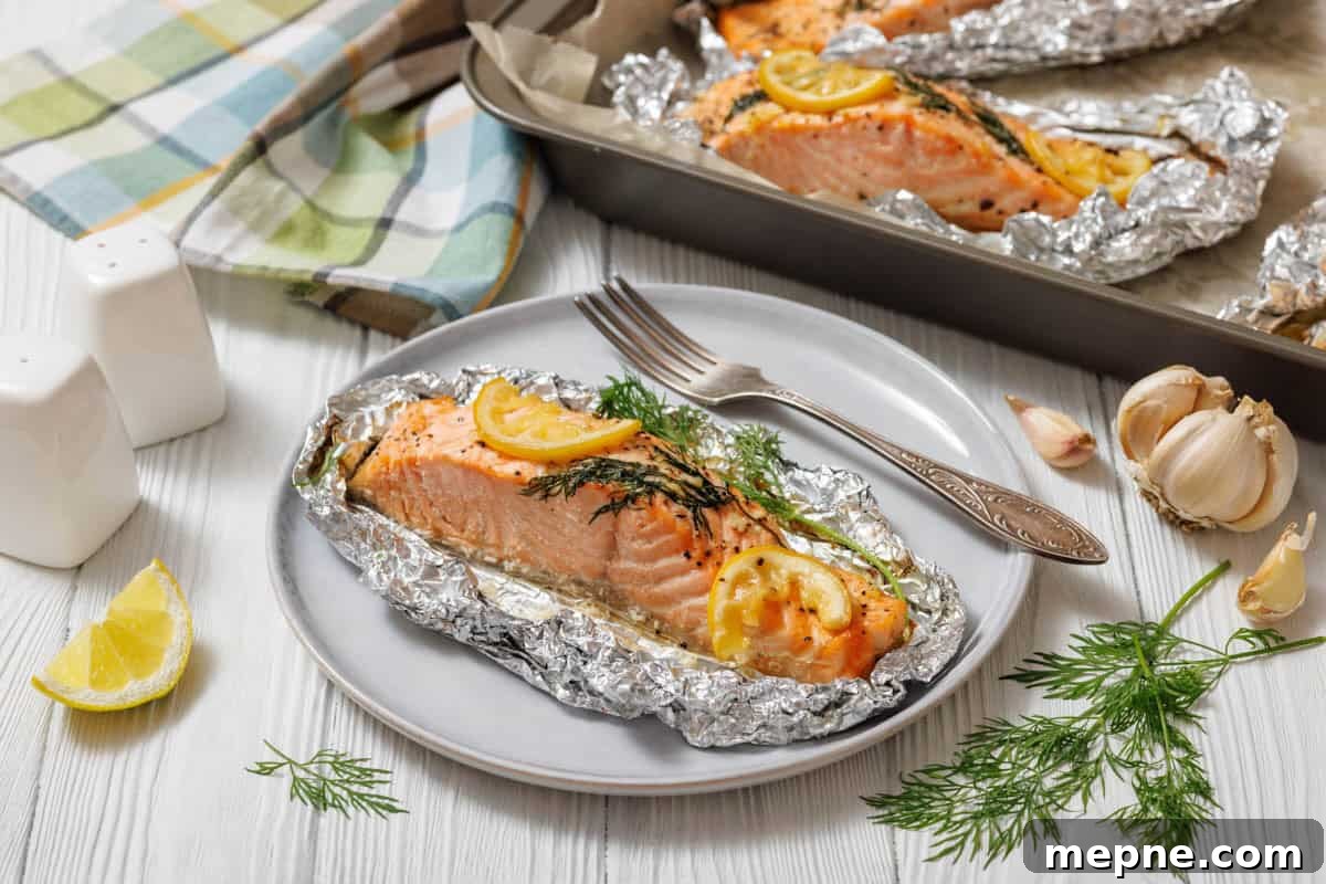 33 BBQ Recipes That Turn Budget Cuts Into Gourmet Meals 13 A close-up, slightly high-angle shot of a single Lemon Dill Salmon Foil Packets , seasoned with lemon and dill, still nestled in its aluminum foil packet on a light gray plate, with a silver fork to its right.