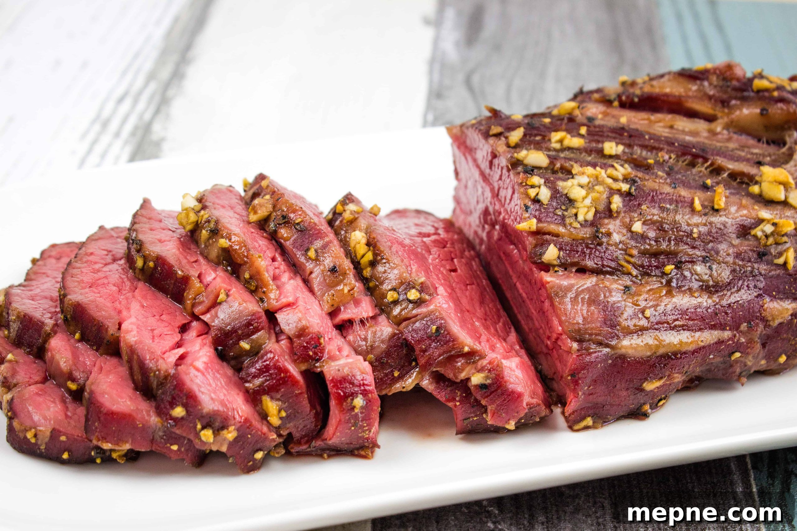 33 BBQ Recipes That Turn Budget Cuts Into Gourmet Meals 18 A sliced smoked beef tenderloin on a white plate.