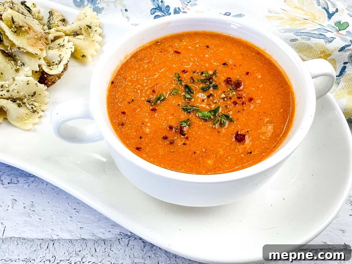 33 BBQ Recipes That Turn Budget Cuts Into Gourmet Meals 23 A bowl of smoked tomato soup with mascarpone, garnished with herbs and chili flakes, served with seasoned pasta on a white plate.