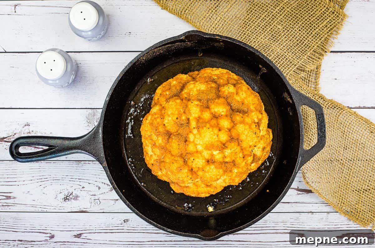 33 BBQ Recipes That Turn Budget Cuts Into Gourmet Meals 26 Smoked cauliflower in a skillet on a wooden table.