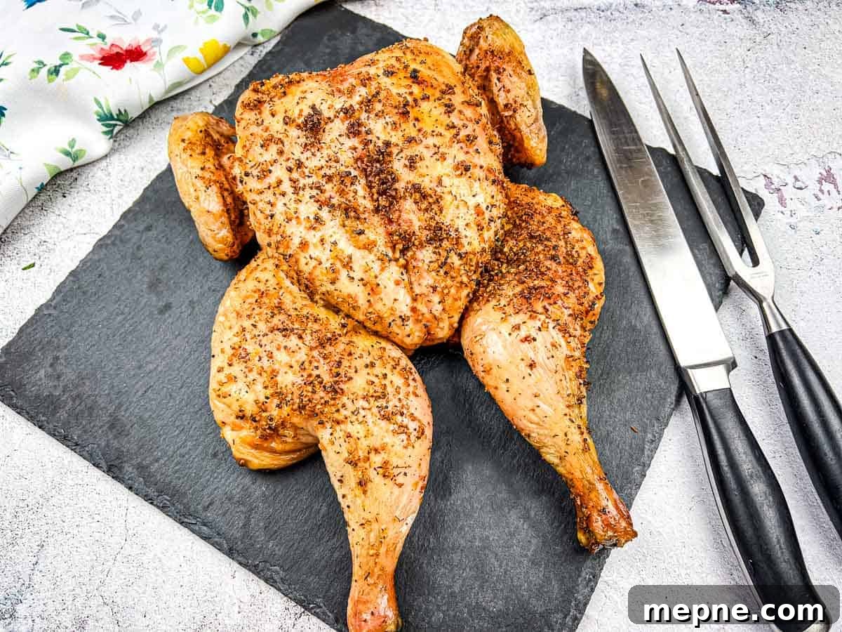 33 BBQ Recipes That Turn Budget Cuts Into Gourmet Meals 28 Roasted chicken on a slate board with carving knife and fork.