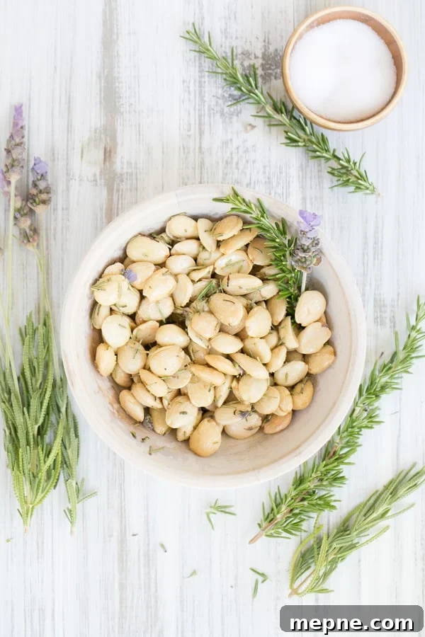 How to Make Lavender and Rosemary Marcona Almonds 2 Marcona almonds with lavender and rosemary in a bowl.
