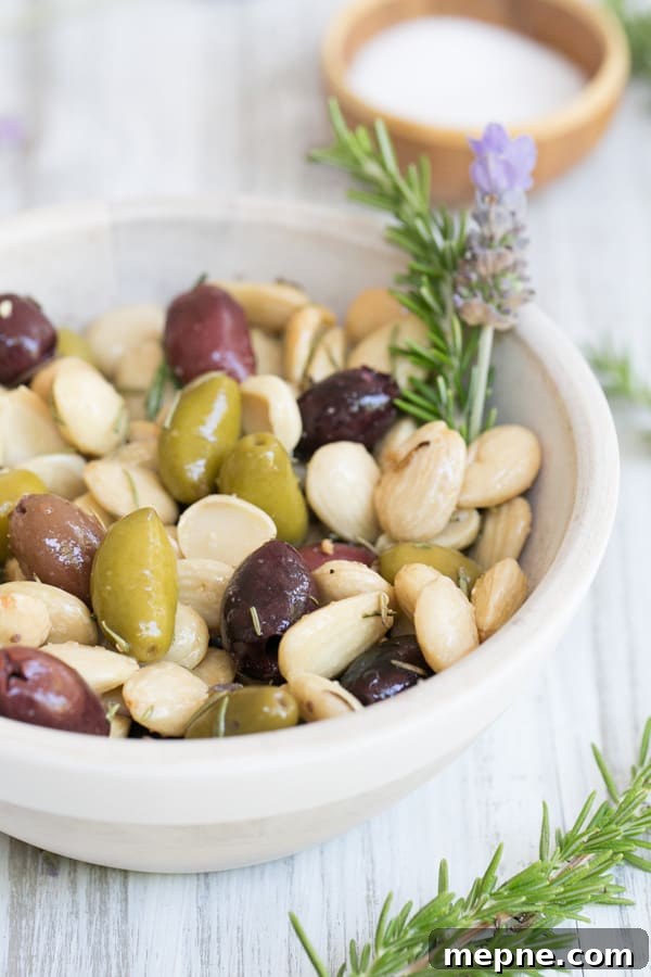 How to Make Lavender and Rosemary Marcona Almonds 4 Marcona Almonds with olives, rosemary and lavender in a small bowl.